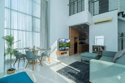 a living room with a couch and a table and chairs at 2BR Maritime Suite Duplex George Town SeaView in George Town