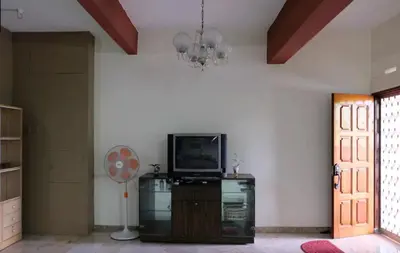 a living room with a television and a fan at Taiping Lake View in Gua Sai