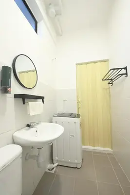 a white bathroom with a sink and a mirror at Yeop & Chor Homestay in Seri Iskandar
