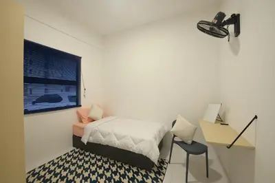 a small bedroom with a bed and a desk at Yeop & Chor Homestay in Seri Iskandar