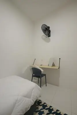 a bedroom with a bed and a desk and a chair at Yeop & Chor Homestay in Seri Iskandar