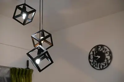 a cluster of lights hanging from a wall with a clock at Yeop & Chor Homestay in Seri Iskandar