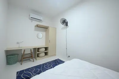 a bedroom with a bed and a sink and a desk at Yeop & Chor Homestay in Seri Iskandar