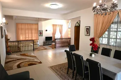 a living room with a dining room table and chairs at BUNGALOW POOL, NETFLIX, BBQ And BATU FERRINGHI in Batu Ferringhi