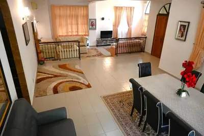 a living room with a dining table and a living room at BUNGALOW POOL, NETFLIX, BBQ And BATU FERRINGHI in Batu Ferringhi