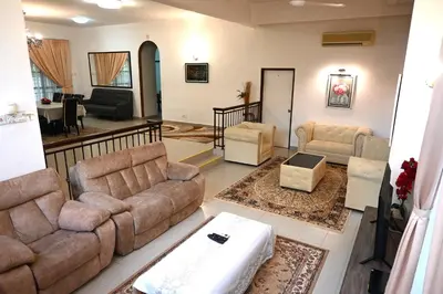 a living room with two couches and a table at BUNGALOW POOL, NETFLIX, BBQ And BATU FERRINGHI in Batu Ferringhi