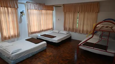 two beds in a room with two bunk beds at BUNGALOW POOL, NETFLIX, BBQ And BATU FERRINGHI in Batu Ferringhi