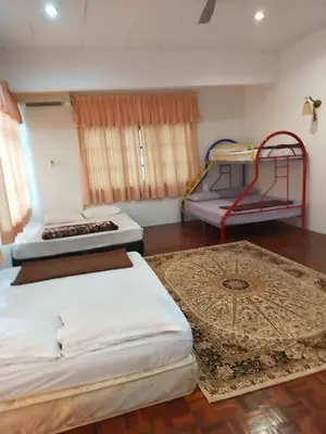 a bedroom with two beds and a table at BUNGALOW POOL, NETFLIX, BBQ And BATU FERRINGHI in Batu Ferringhi