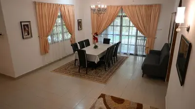 a dining room with a table and black chairs at BUNGALOW POOL, NETFLIX, BBQ And BATU FERRINGHI in Batu Ferringhi