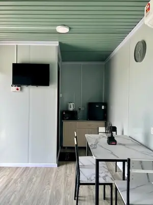 a dining room with a table and chairs and a tv at TeeDo Zzz in Parit Buntar