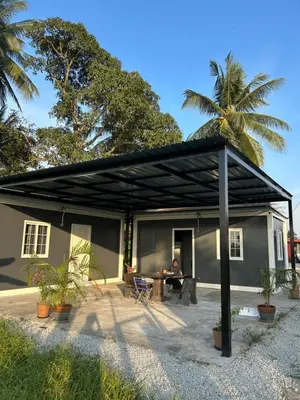 a man sitting in a patio of a house at TeeDo Zzz in Parit Buntar