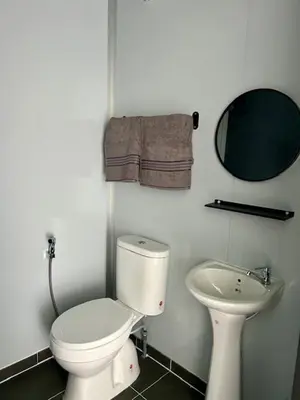 a white bathroom with a toilet and a sink at TeeDo Zzz in Parit Buntar