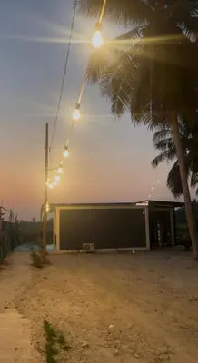 a street light with a building and a palm tree at TeeDo Zzz in Parit Buntar