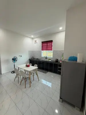 a kitchen with a table and chairs in a room at Adlisem Homestay in Kampong Lahar Yooi