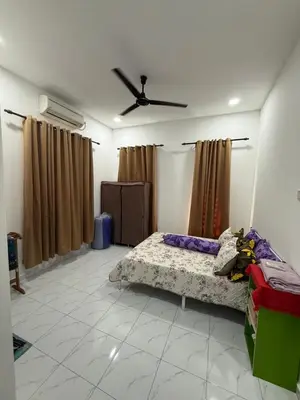 a bedroom with a bed and a ceiling fan at Adlisem Homestay in Kampong Lahar Yooi