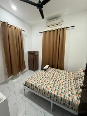 a bedroom with a bed in a room with curtains at Adlisem Homestay in Kampong Lahar Yooi