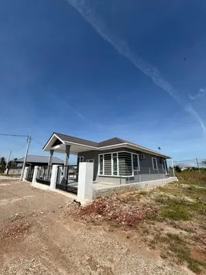 a house in a field with a blue sky at Adlisem Homestay in Kampong Lahar Yooi