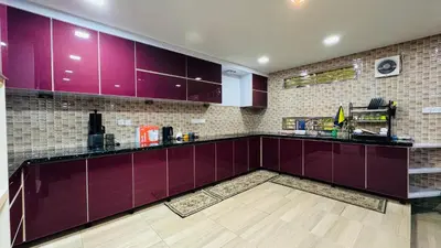a kitchen with purple cabinets and a wooden floor at Homestay, Lunas Kulim near BKE highway with 3 spacious rooms and fully furnished in Lunas