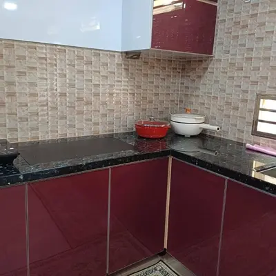 a kitchen with red cabinets and a counter top at Homestay, Lunas Kulim near BKE highway with 3 spacious rooms and fully furnished in Lunas