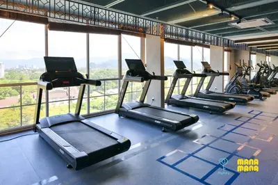 a row of treadmills in a gym with windows at Stallionz by Mana Mana in Ipoh