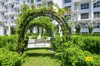 an arch with a bench in a garden at Stallionz by Mana Mana in Ipoh