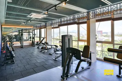 a gym with treadmills and exercise equipment and windows at Stallionz by Mana Mana in Ipoh