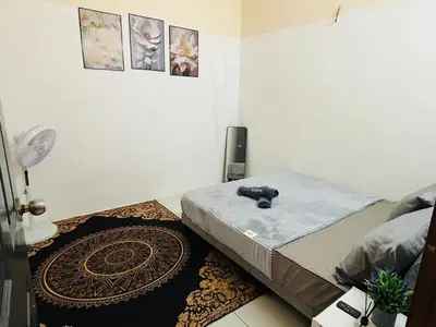 a bedroom with a bed and a rug at Izzu Homestay Sungkai in Sungkai