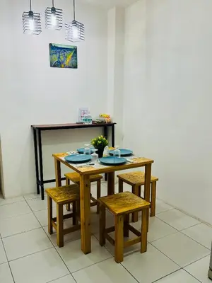 a dining room table with chairs and a table with plates at Izzu Homestay Sungkai in Sungkai