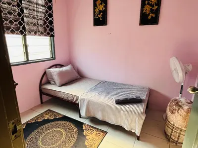 a small room with a bed and a pink wall at Izzu Homestay Sungkai in Sungkai