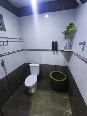a bathroom with a toilet and a green bucket at Dreamy Stay Penang in Butterworth