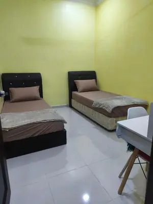 two beds in a room with green walls at Dreamy Stay Penang in Butterworth