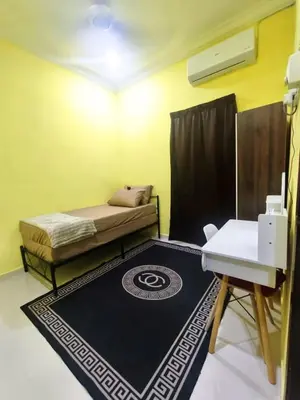 a room with a bed and a table and a rug at Dreamy Stay Penang in Butterworth