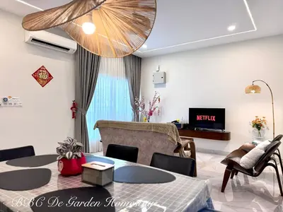 a living room with a table and chairs and a television at BBC De Garden Homestay in Ipoh