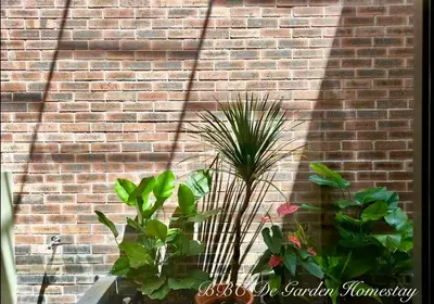 a brick wall with some plants in front of it at BBC De Garden Homestay in Ipoh