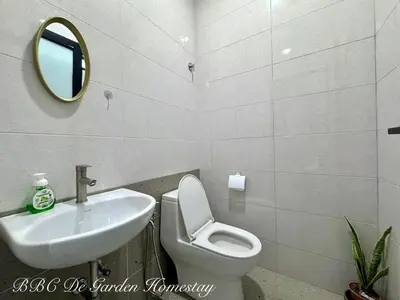 a bathroom with a sink and a toilet and a mirror at BBC De Garden Homestay in Ipoh