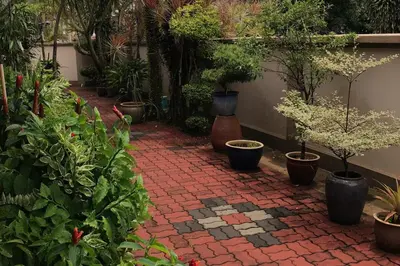 a brick walkway with potted plants in a garden at Garden vibe STAYcation Hillside in Ipoh