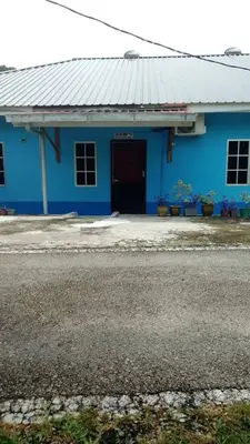a blue building with a door in front of it at Roomstay Zai Sungai Klah in Kampung Jeram Kawang