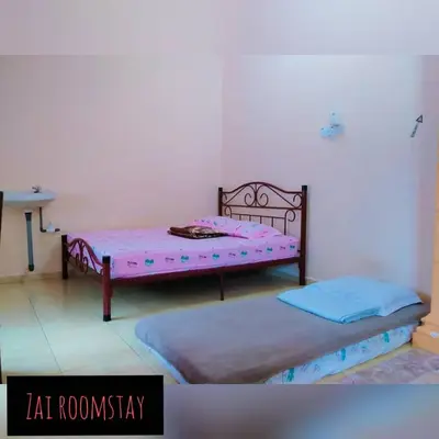 two beds are in a room with at Roomstay Zai Sungai Klah in Kampung Jeram Kawang