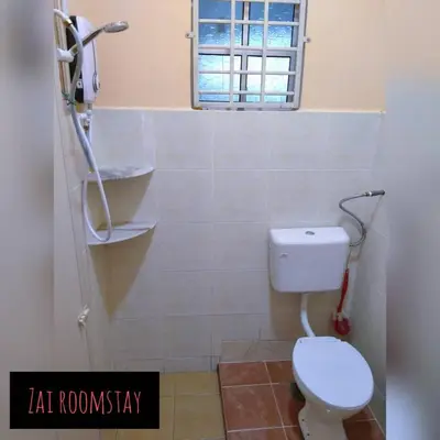 a bathroom with a white toilet and a window at Roomstay Zai Sungai Klah in Kampung Jeram Kawang