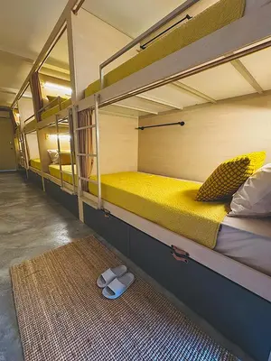 a room with two bunk beds and a rug at Strangerland Hostel in Ipoh