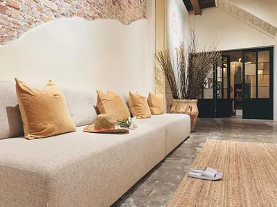 a living room with a white couch with pillows at Strangerland Hostel in Ipoh