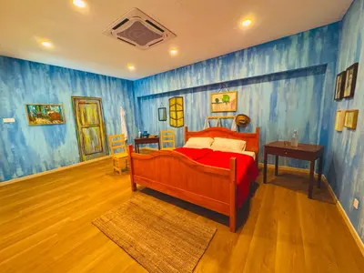 a bedroom with a bed and blue walls at Strangerland Hostel in Ipoh