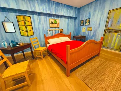 a bedroom with a bed with a red comforter at Strangerland Hostel in Ipoh