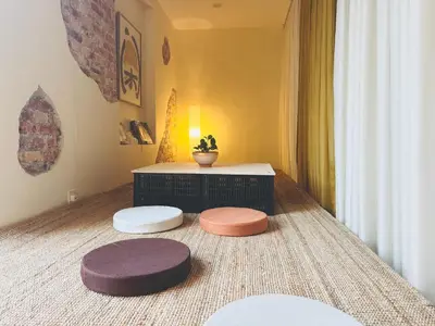 a living room with three ottomans and a table at Strangerland Hostel in Ipoh