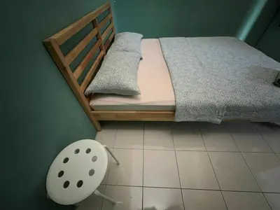 a small bedroom with a bed and a chair at Adila Homestay in Seri Iskandar