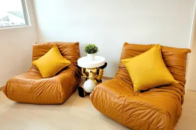 two orange chairs with yellow pillows in a room at K Room Homestay at Taiping in Taiping
