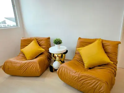 two orange chairs in a room with a table at K Room Homestay at Taiping in Taiping
