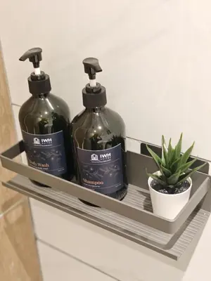 two bottles of soap and a plant on a shelf at Piccadilly Greentown Premium Suites by IWH Suites in Ipoh