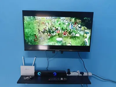 a flat screen tv hanging on a blue wall at Homestay Sayang in Ipoh