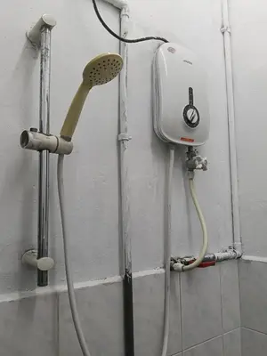 a shower head and a blow dryer on a wall at Homestay Sayang in Ipoh